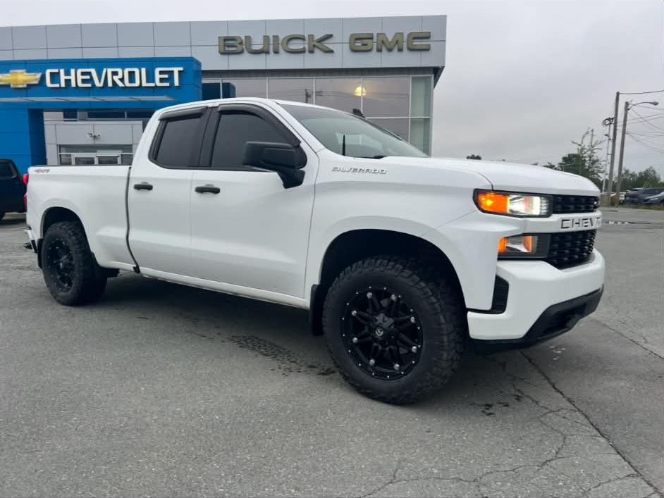 White pickup parked outside a vehicle dealership