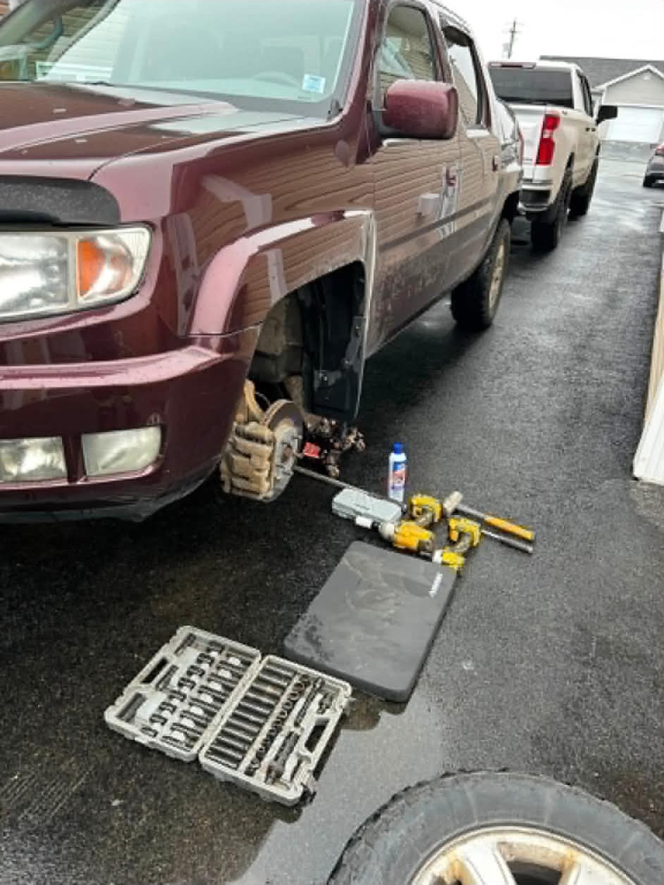 A vehicle raised for service with tools arranged beside it